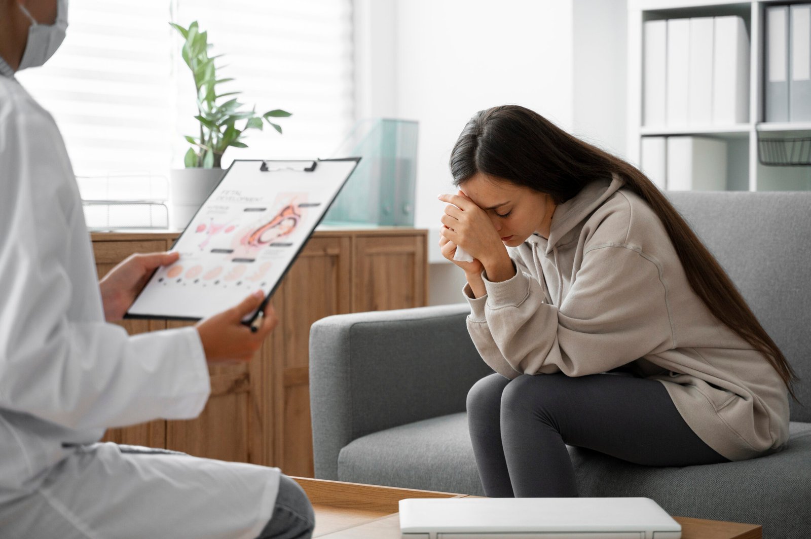 Woman in distress consulting a doctor about reproductive or mental health
